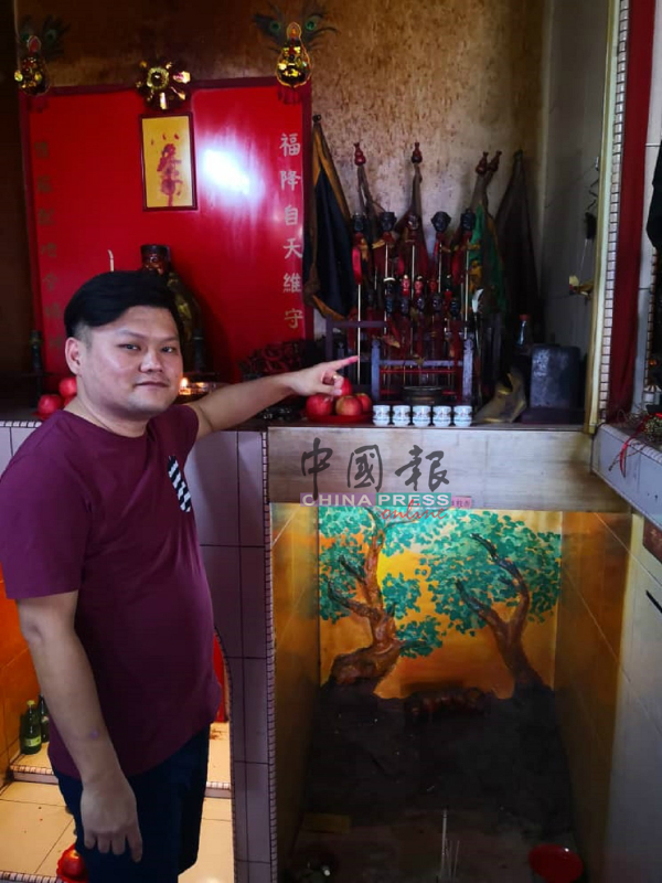 刘汉耀展示置放圣君宝剑的神桌。