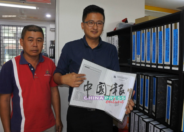 谢守钦（右）展示所接获的民生投诉及档案。右为新马六甲花园乡理会主席洪清顺。