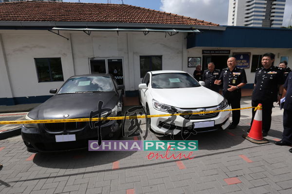 在李庆泉（右起）陪同下，莫哈末卡马鲁丁向媒体讲解，柔州肃毒组所充公的两辆轿车。