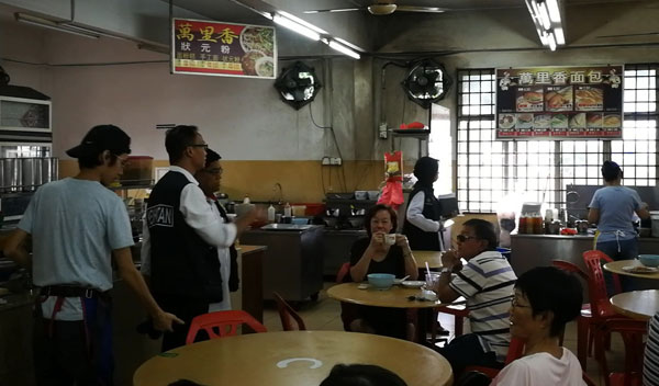 居銮卫生局监督及法律小组主任安努亚（左）陪同尼占到咖啡店进行检查，确保业者和食客都遵守条例。
