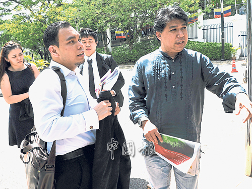 嘉哈峇（右）抵達武吉阿曼警察總部入口處，在律師和律師助理陪同下錄取口供。