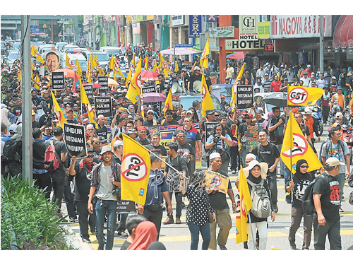 集會者高喊口號、手拿著旗子和海報，一路遊行到集會目的地。