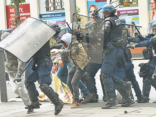 防暴警察以警棍對付施暴的示威者。（法新社） 