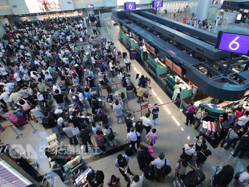 桃园机场旅客大排长龙 ，不少旅客心急如焚。 （中央社）