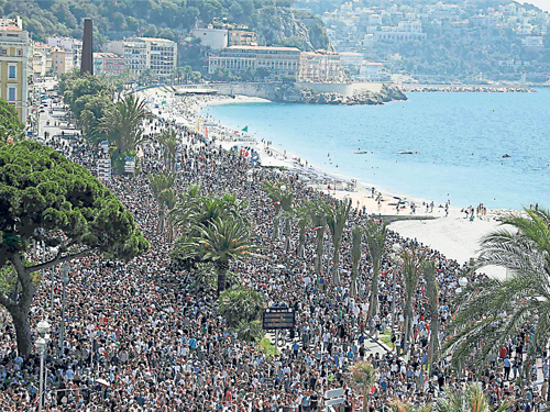 法国哀悼日第3天，大批人群沿着海滨大道向罹难者致敬默哀。（路透社）
