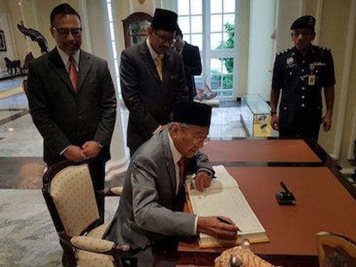 马哈迪周四下午到吉打王宫觐见端姑阿都哈林时，在签到簿上签名。(图/ The Malaysian Mirror)