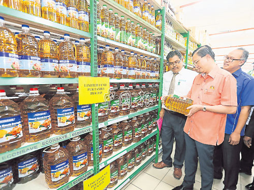  ■鄭修強（左2）了解宜康省的食油銷售情況。