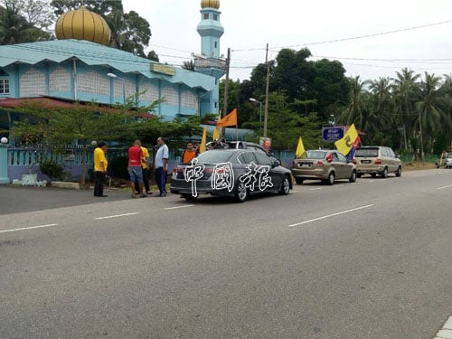 一群相信是巫統黨員的人士，在巴力沙浪峇野插黨旗，力阻車隊進入麻坡。