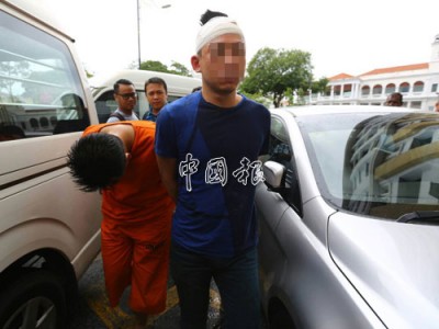 保鏢和另一名華裔男子週五被帶上法庭申請延扣7天。保鏢全程彎腰低頭，頭上還包紮傷口的華裔男子（右）則沒躲避鏡頭。
