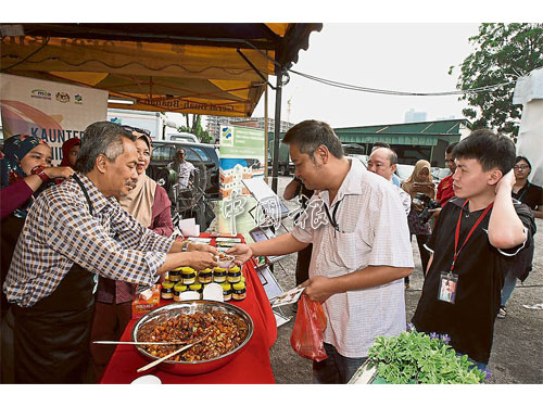 阿末依薩（左）親自向顧客兜售馬來亞惹（acar）。