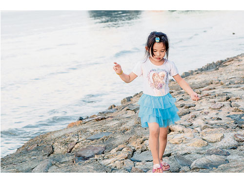 杜正偉閑暇帶著小侄女到麻坡黃金丹絨散步，見她踩在河床石上展現的童真，馬上舉起相機拍下。