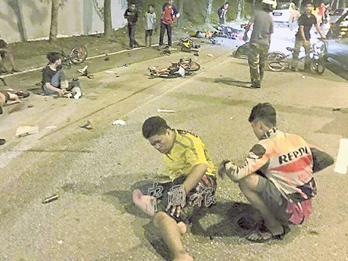 兩名傷者案發后,坐在路上等待救援。