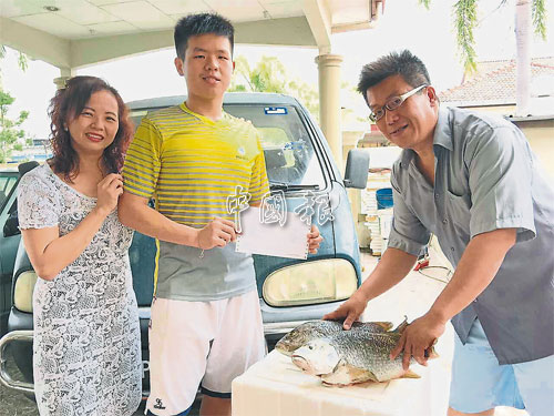  俊祥（左2）向忙碌準備鮮魚的父親張振成展示考獲10A成績單，左為林義真。