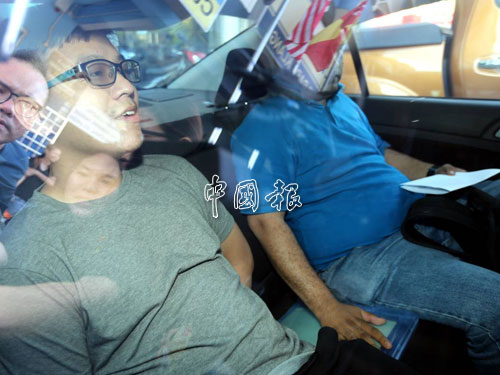 李宗聖在警車上臉帶微笑，看不出有擔心的神情。