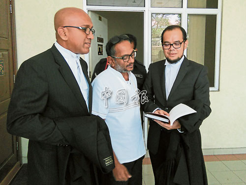 獲撒回提控的西華古馬（中）在辯護律師哈利斯（左）的陪同下，離開法庭。