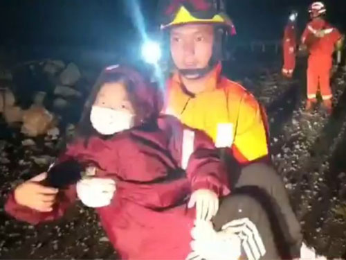 救援人員抱著一名女童離開災場。