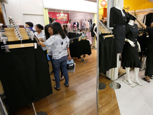 曼谷一購物商場擺放很多黑色衣服，讓準備出席葬禮的民眾選購。（美聯社）
