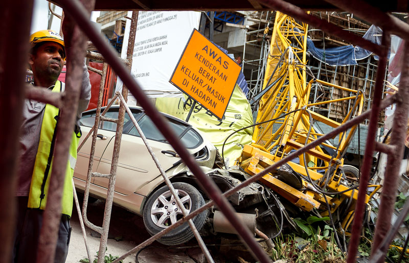 為一輛泊在工地旁的奔舒娜轎車被吊臂泰山壓頂，毀不成形。