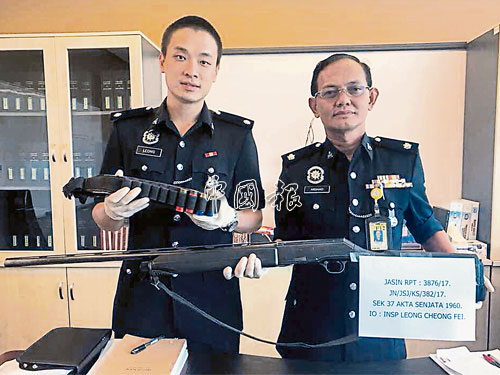  阿爾薩阿布（右）及梁昌輝，展示警方扣押的槍支及4枚子彈。