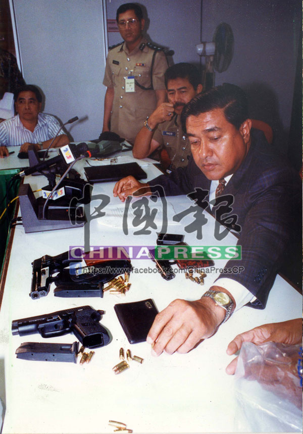 查干曼（右）在記者會上展示起獲的槍械。
