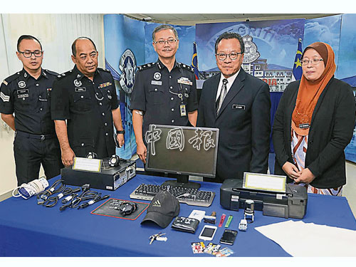 孫頭程（中）與峇德魯（左2起）及羅斯迪，展示警方從主謀家中起獲的電腦和打印機器材。