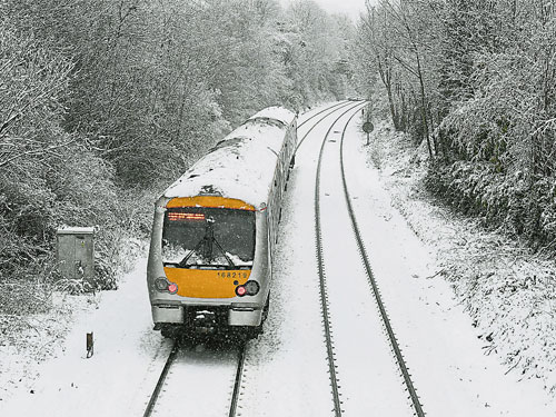 英國高威科姆鎮的火車軌道被白雪覆蓋，一列火車緩緩駛過。（歐新社）