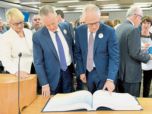  協助澳洲皇家委員會調查的律師蓋爾（左），隨同澳洲總理特恩布爾（右）和在野黨領袖比爾，一同看著兒童性虐待案件受害者的親筆信。（法新社）