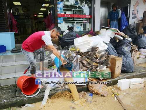 重災區的水位退下後，居民依舊打起精神清除在水災浸壞的物品，並用桶清理堆積在店內的泥水。