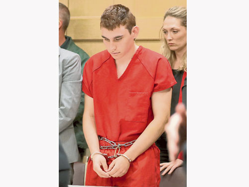  槍手克魯茲出庭受審時身穿紅色囚服，雙手被手銬鎖著放在腰部。（路透社） 