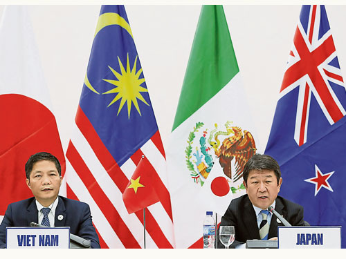  日本經濟產業大臣茂木敏充（右）與越南工商部長陳俊英，去年11月11日在亞太經合組織（APEC）峰會中宣布，TPP的11個會員國已達成新架構共識，將TPP更名為CPTPP。（圖取自彭博社） 