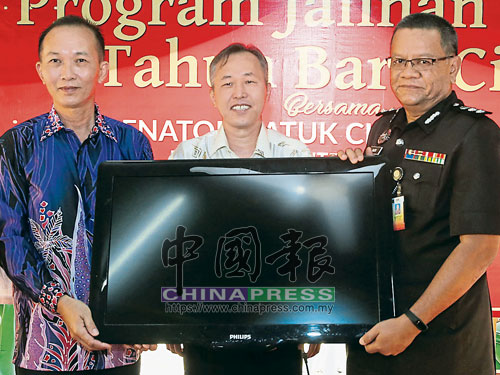 林繼昌（左）代表“覺之家”移交液晶電視予莫哈末納茲里，中為陳松霖。