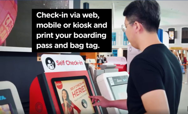 乘客在自助登機系統完成登機程序。(圖取自亞航面子書視頻)