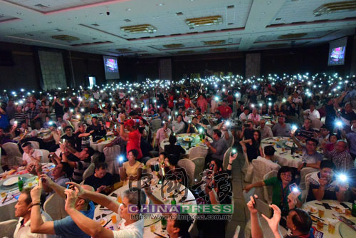 出席者打開手機閃光燈，向台上政治領袖給予支持。