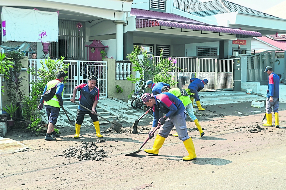 金宝县议会协助居民清理泥浆。