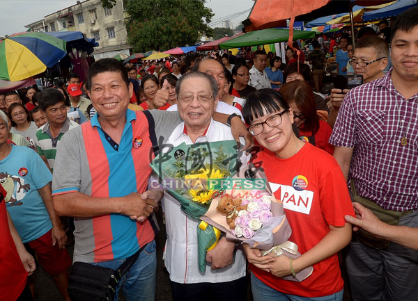 王詩棋（右起）、林吉祥深受無拉港選民歡迎，選民贈送鮮花給他們。 