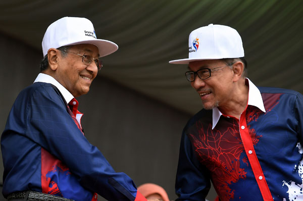  安華（右）在國慶日慶典上與首相馬哈迪同台亮相，兩人心情愉悅。 