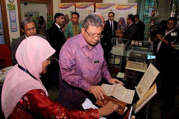  赛夫丁阿都拉（右）在参观马来文献中心时，细心观赏马来文手稿。