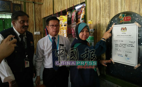 莎兹琳（右起）、王勇元及古迪星，将关店通告贴在马来食肆的墙上。