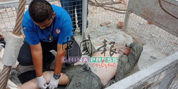 　救护人员对受伤的员工施予紧急救援。