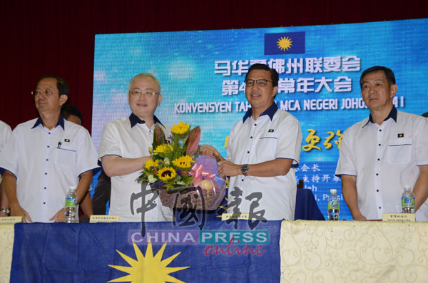 魏家祥（左2）赠送水果礼篮给廖中莱，左为大会议长拿督何襄赞及马华柔州联委会署理主席拿督林培兴（右）。