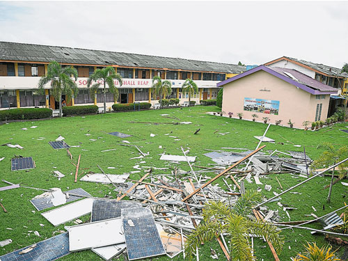 吉华华中周一（24日）遭受狂风暴雨侵袭，导致6栋课室楼遭摧毁，装置在屋顶的太阳能板和锌板散落校园。
