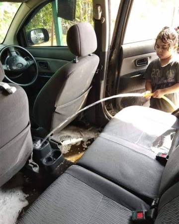 　小女孩认真的手持水管，并开水往车内射，以“清理”车内倒翻的美禄饮料。 　