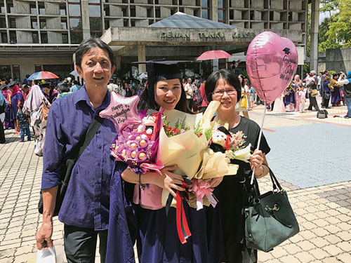 硕士毕业典礼当天，在马大礼堂外与父母合照。