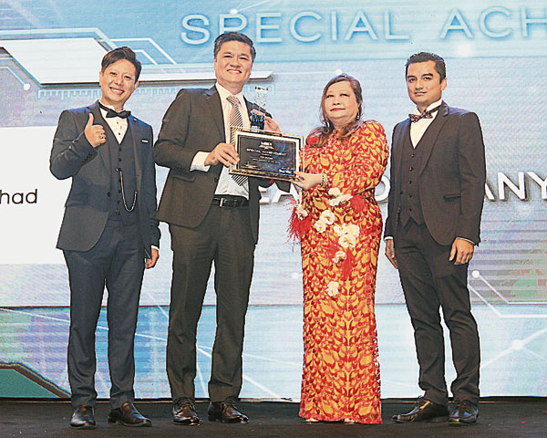 XOX说电讯公司执行董事黄国兴（左2）从彭亨公主东姑梅 丽安（右2）手中接过奖项。左起为MMCP主席林泳煌和前主席佐哈里慕斯达法。