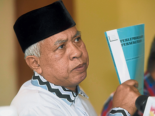 沙列胡丁举起联邦宪法，称要捍卫马来文和伊斯兰的地位。