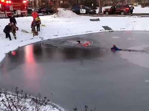 男孩掉进冰池里，消防员合作解救。