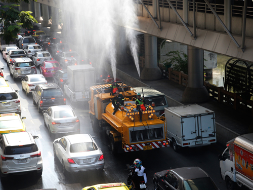 曼谷市政员工周一在街道上喷水，藉此减缓烟霾问题。（美联社）