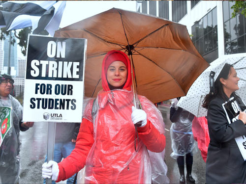 加入罢工行列的小学老师波希克，拿着“罢工，为了我们的学生”的标语牌游行。（法新社）