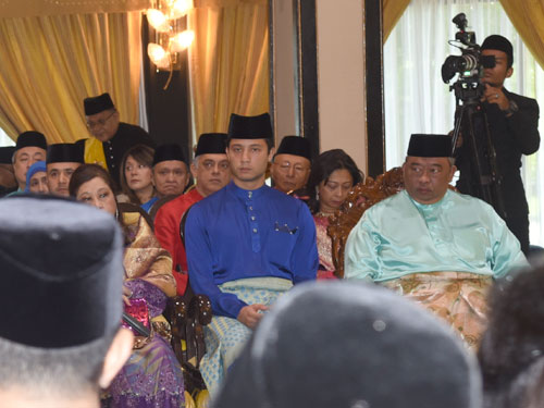 东姑法哈身穿蓝色马来服，出席王兄苏丹阿都拉殿下的昭告仪式。