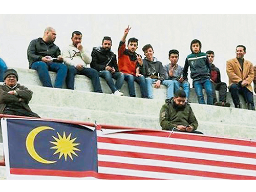 巴勒斯坦足球爱好者，将马来西亚国旗悬挂在亚尔穆克体育馆的观众席。